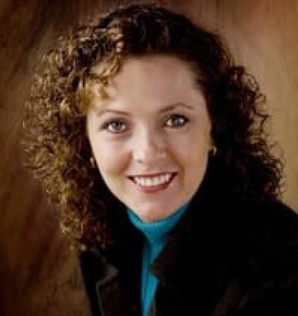 Professional headshot of Aura Marcela Torres DDS smiling at camera in business attire.