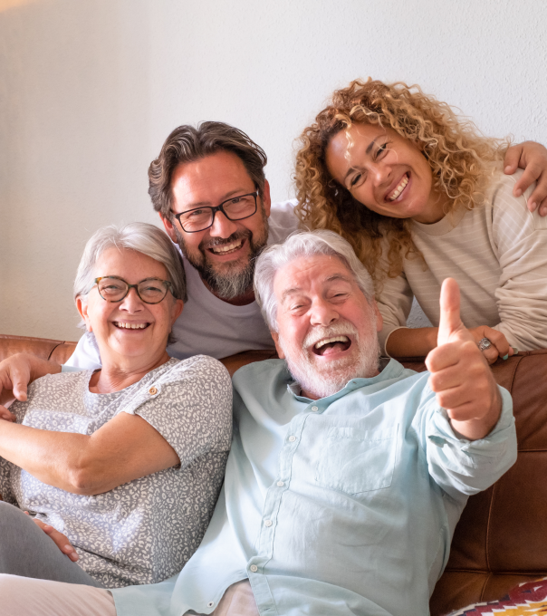 Happy multi-generational family smiling together indoors, showing warmth and togetherness.