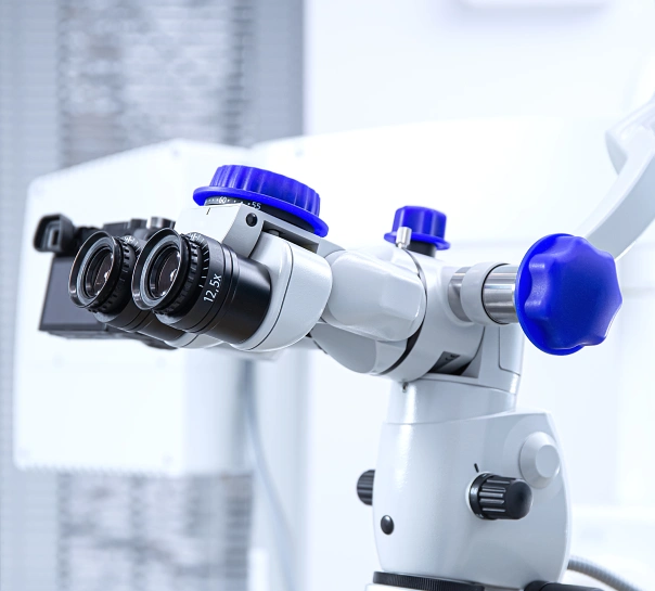 Dental operating microscope with blue eyepieces and controls in clinical setting