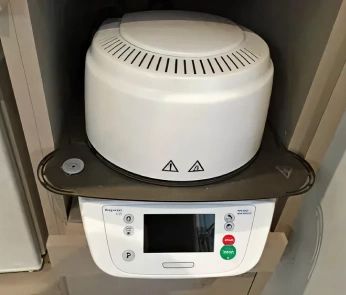 Dental autoclave sterilizer equipment mounted in cabinet with control panel display.