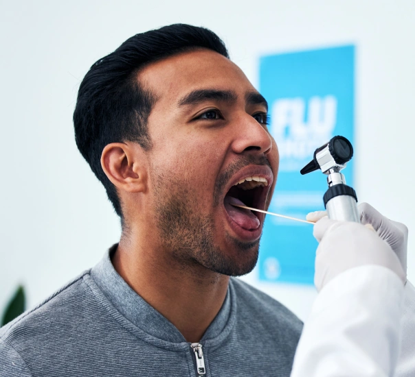 Man singing into microphone at professional event with blue backdrop