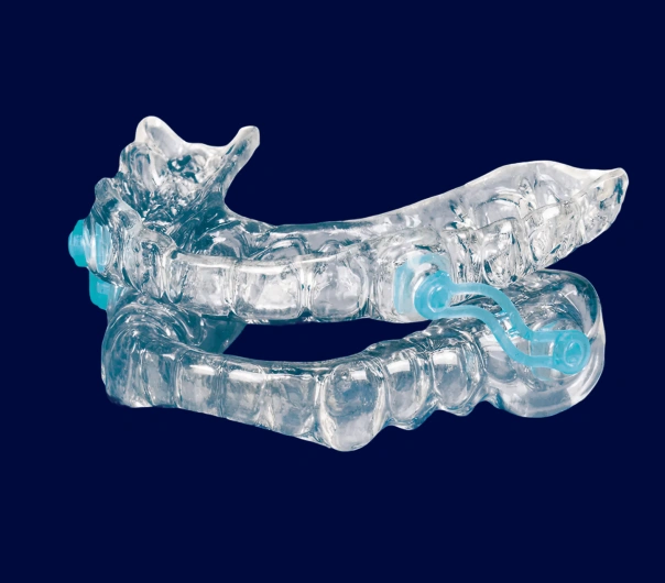 Clear dental aligners displayed against dark blue background, showing orthodontic treatment device.
